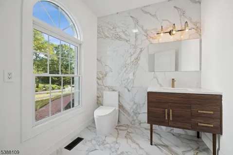a bathroom with a sink a toilet and a window