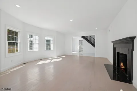 an empty room with windows and fireplace