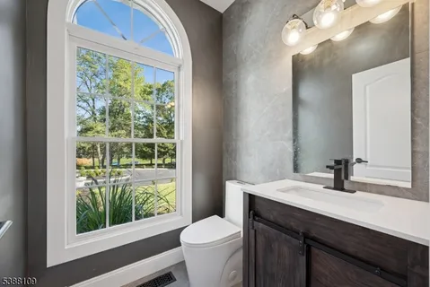 a bathroom with a sink toilet and a mirror