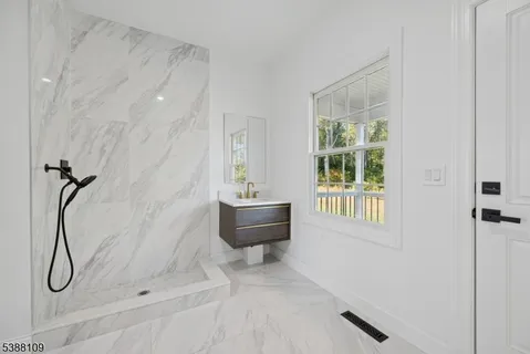 a bathroom with a granite countertop sink a toilet and shower