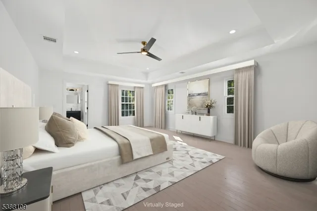a bedroom with a large bed and ceiling fan