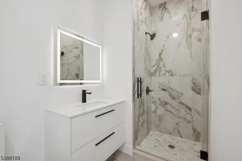 a bathroom with a shower sink and mirror