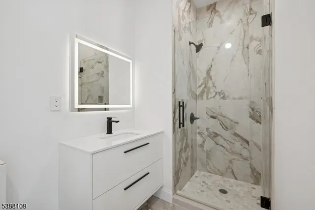 a bathroom with a shower sink and mirror