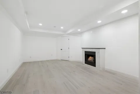 an empty room with a fireplace and wooden floor