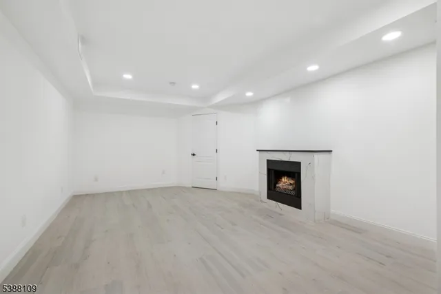 an empty room with a fireplace and wooden floor
