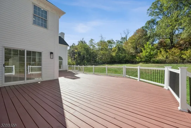 a view of a deck with wooden floor and fence next to a yard