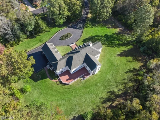 an aerial view of residential house with outdoor space and trees all around
