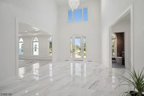 a view of a hallway with wooden floor and a bathroom