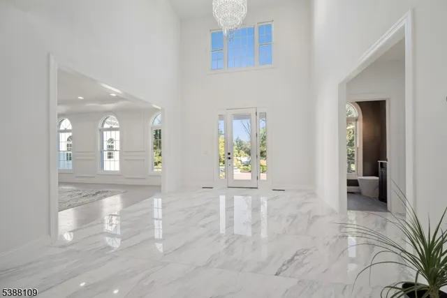 a view of a hallway with wooden floor and a bathroom