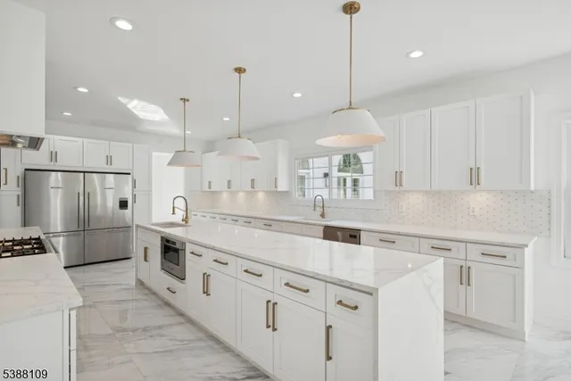 a kitchen with stainless steel appliances granite countertop a sink a oven a refrigerator and white cabinets