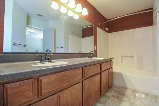636 Heather Court Ridgecrest, CA 93555 - Photo 24 of 33 a bathroom with a double vanity sink a mirror and a bathtub