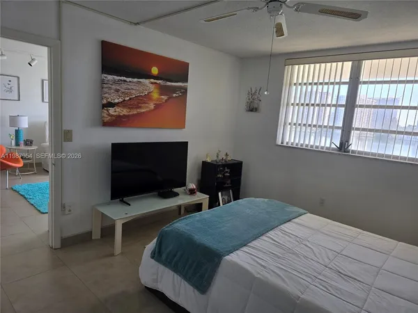 a bedroom with a bed and a flat screen tv