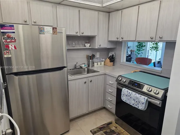 a kitchen with stainless steel appliances a refrigerator sink and cabinets