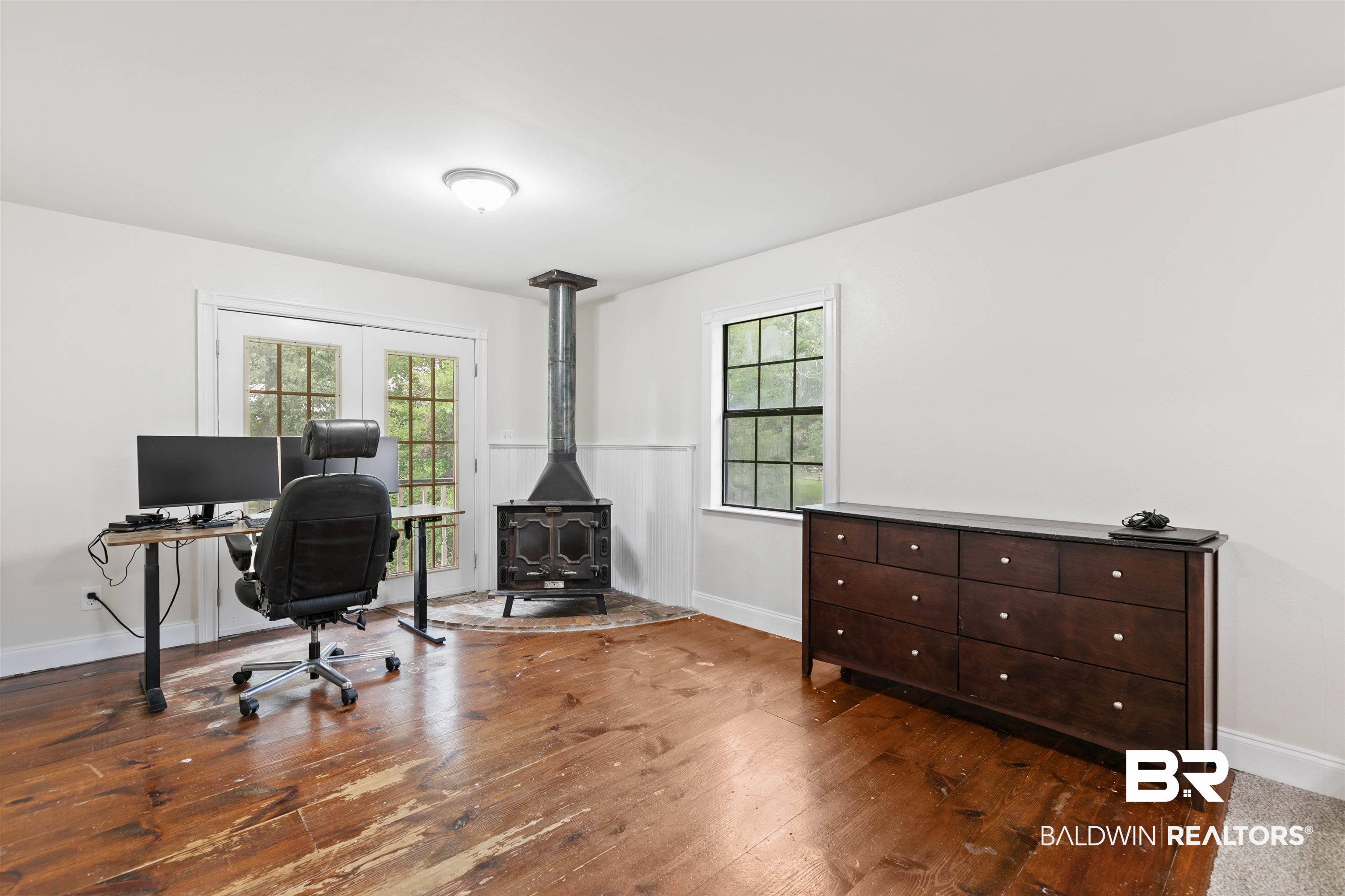 10420 Johnson Road South Mobile, AL 36695 - Photo 43 of 75 Room featuring wood-finish flooring, a freestanding wood-burning stove with a metal flue, and a hearth