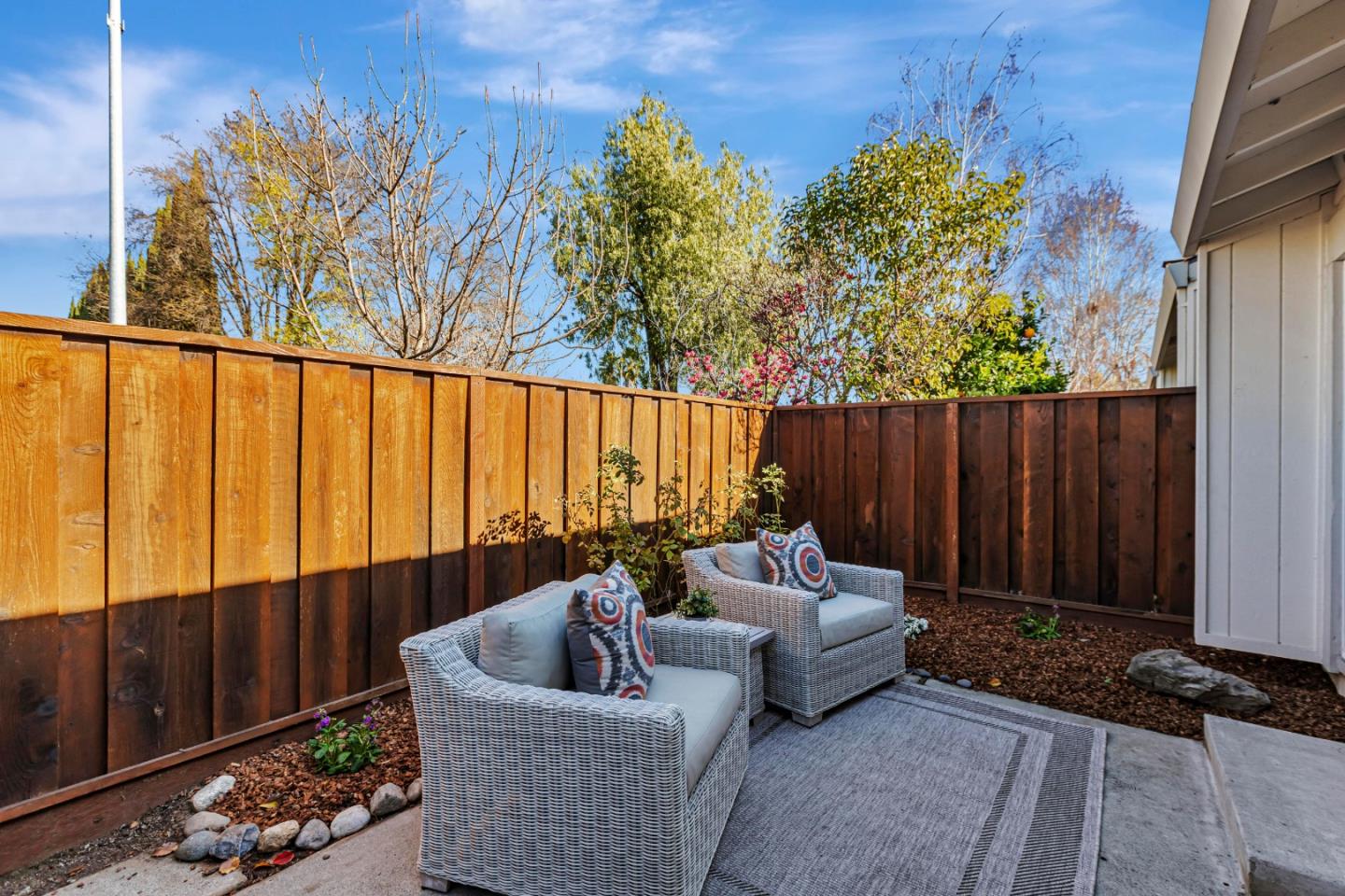 10995 Northseal Square Cupertino, CA 95014 - Photo 22 of 26 a backyard of a house with couches plants and wooden fence