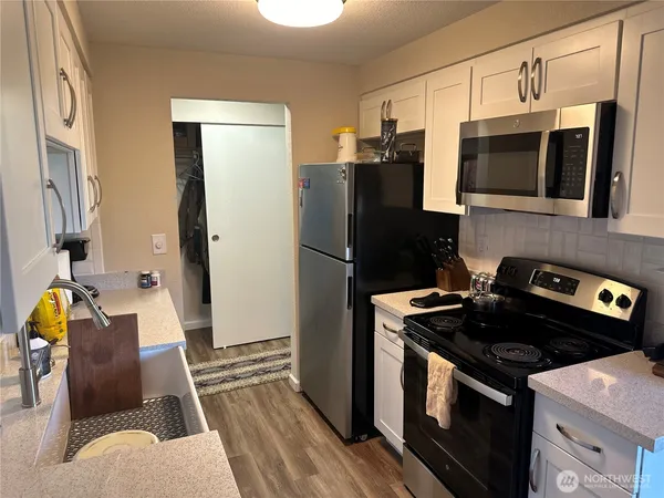 a kitchen with stainless steel appliances granite countertop sink stove and refrigerator