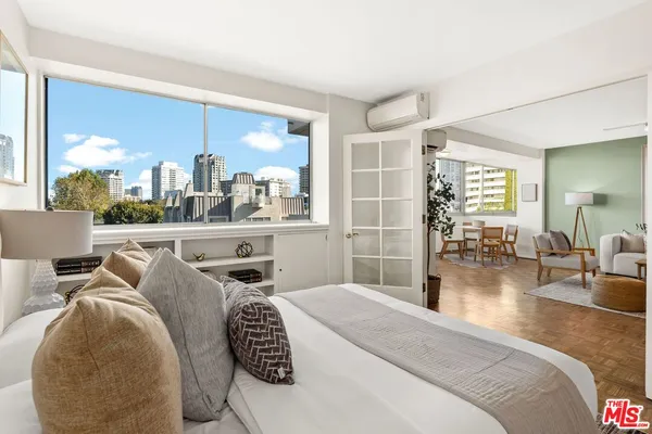 a bedroom with furniture and a large window