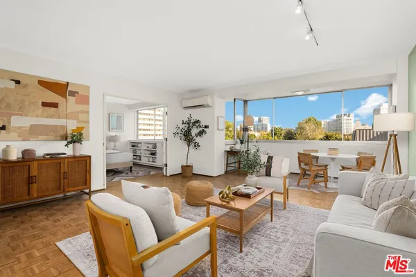 a living room with furniture and view of kitchen