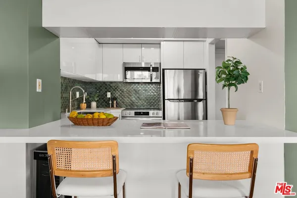 a kitchen with stainless steel appliances granite countertop a refrigerator and a stove