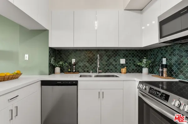 a kitchen with stainless steel appliances granite countertop a sink and a stove