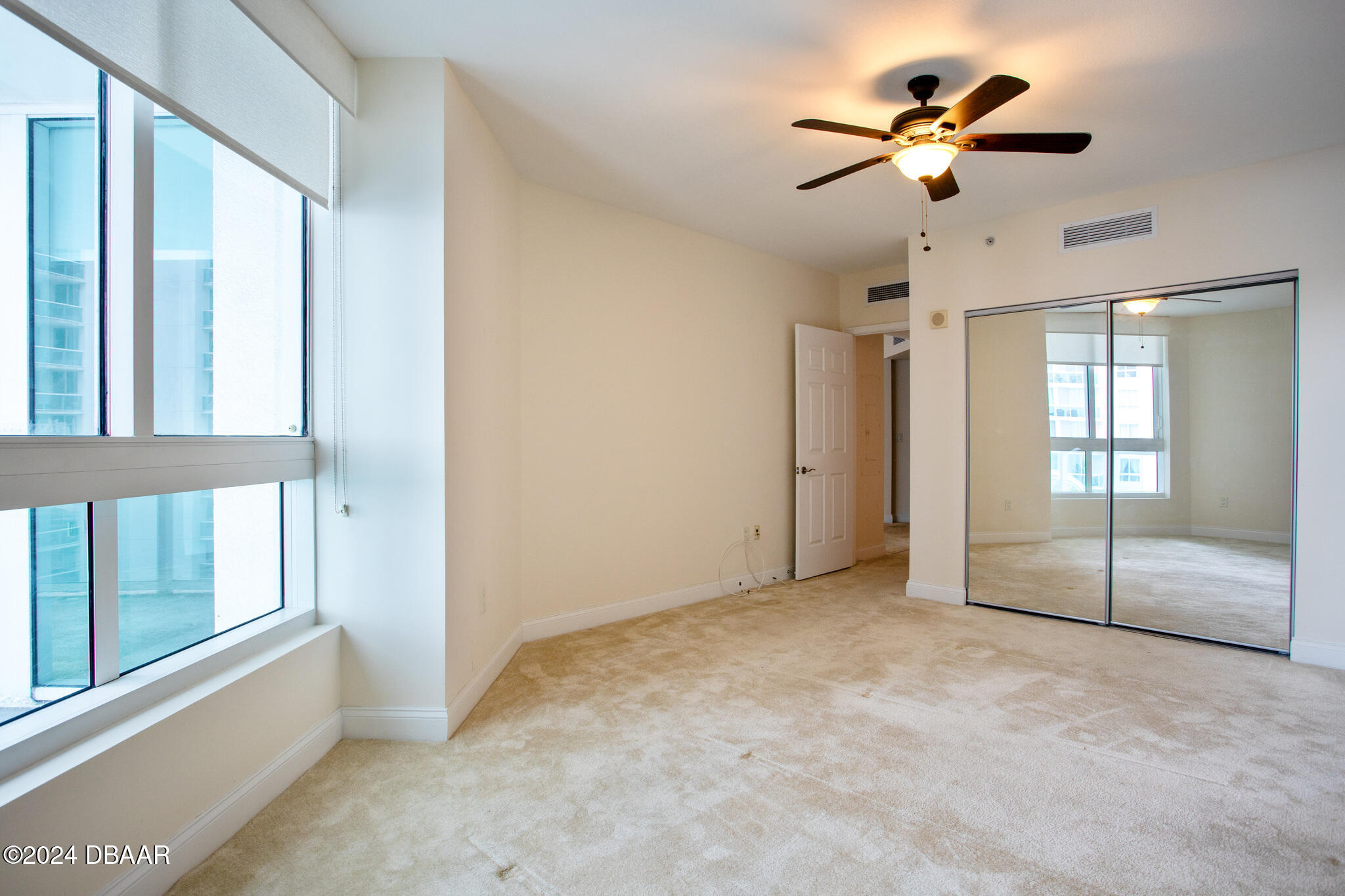 241 Riverside Drive Daytona Beach, FL 32117 - Photo 11 of 20 an empty room with chandelier fan and windows