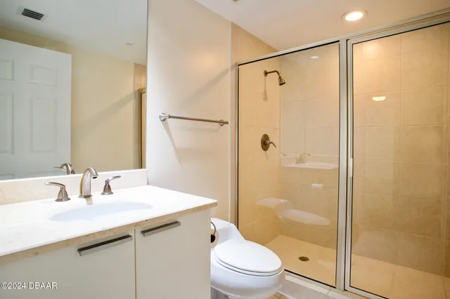 a bathroom with a shower sink vanity mirror and toilet