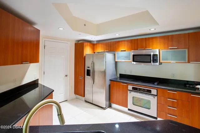 a kitchen with stainless steel appliances granite countertop a stove a sink and a microwave