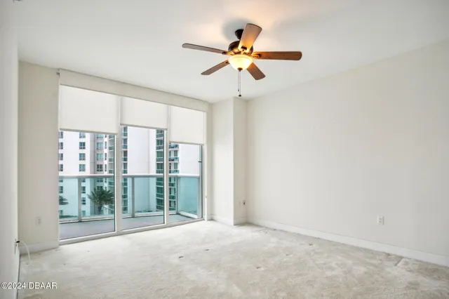 a view of a room with a ceiling fan and window