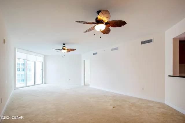 an empty room with a window and a ceiling fan