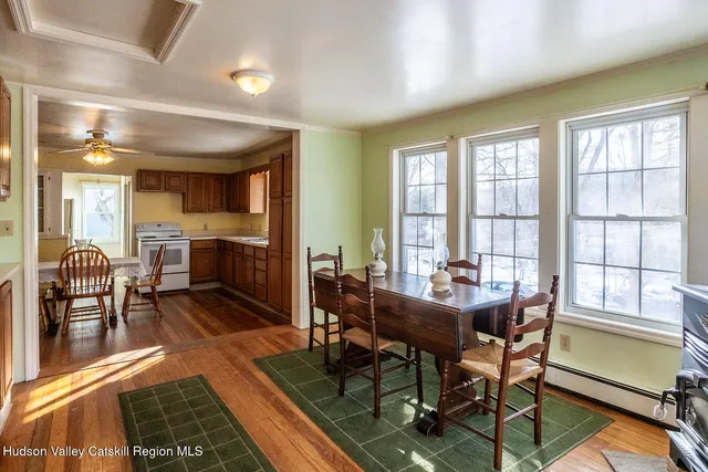 a dining room with furniture a rug and a large window