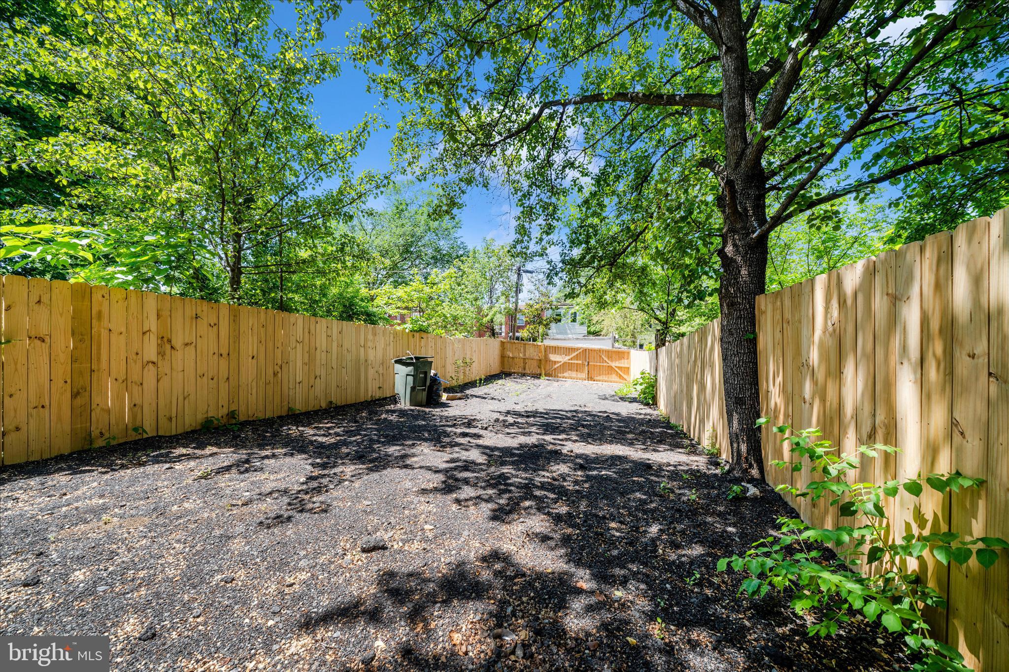 5027 Benning Road Southeast Washington, DC 20019 - Photo 56 of 57 a view of a backyard with large trees and wooden fence
