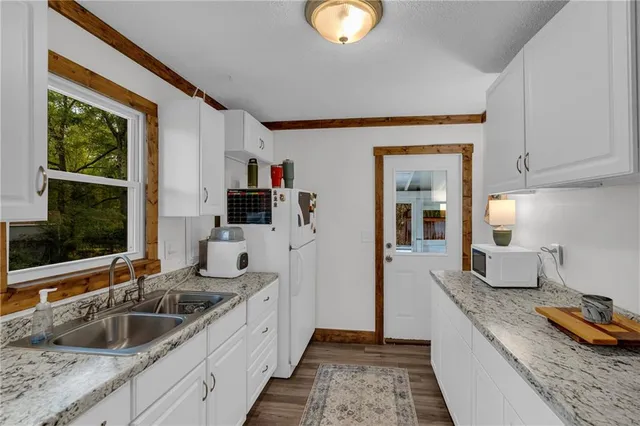 a kitchen with granite countertop a sink and a stove top oven