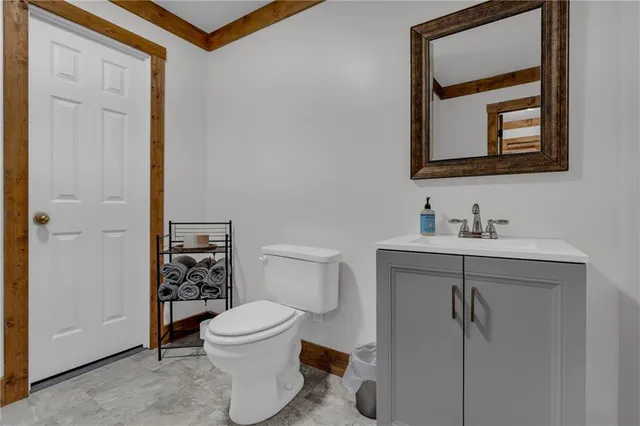 a bathroom with a toilet a sink and mirror