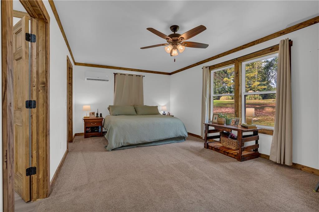 1334 Joe Bolton Road Commerce, GA 30530 - Photo 20 of 45 a bedroom with a bed and a chandelier