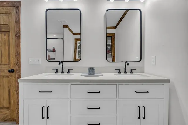 a bathroom with double vanity sinks and a mirror