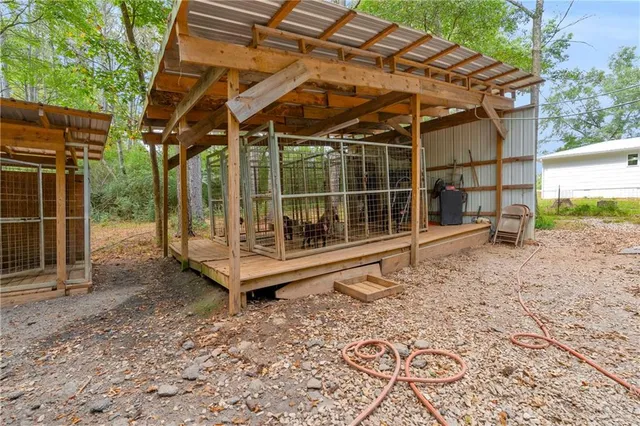 a view of a wooden house with a wooden bench in a backyard