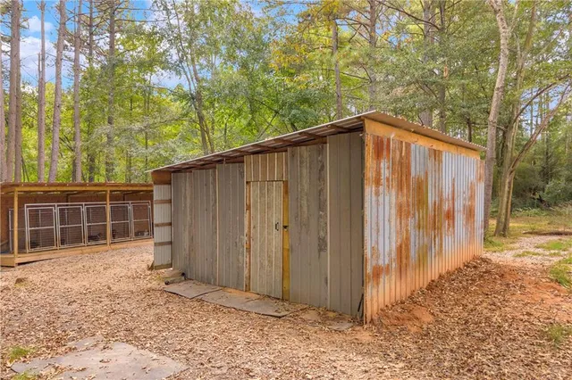 a backyard of a house with a large tree and wooden fence