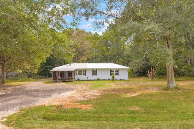 a view of a house with yard and sitting area