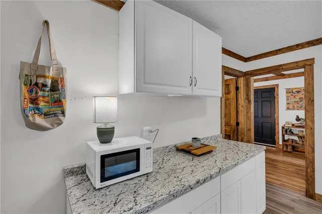 a kitchen with stainless steel appliances granite countertop a sink dishwasher stove and microwave with wooden floor
