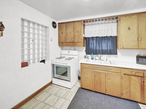 10748 S Avenue North Chicago, IL 60617 - Photo 8 of 19 a kitchen with a sink stove and cabinets