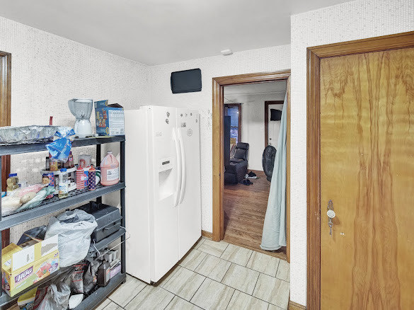 10748 S Avenue North Chicago, IL 60617 - Photo 9 of 19 a view of a livingroom with wooden floor and a refrigerator
