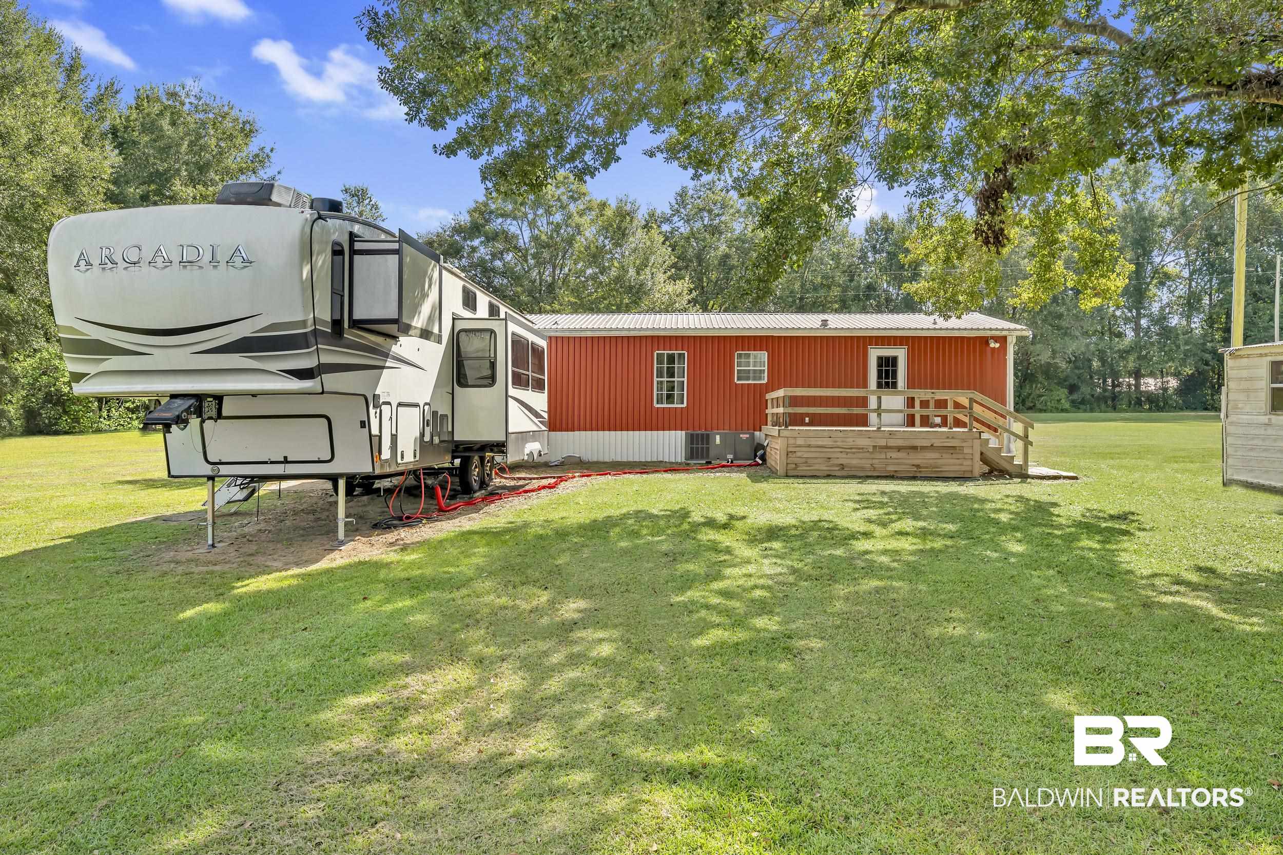 22823 Lanier Road Robertsdale, AL 36567 - Photo 3 of 46 Rear view of house with a yard and a deck