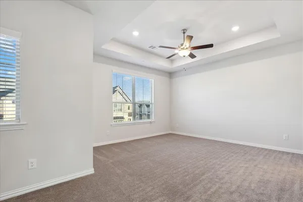 an empty room with windows and ceiling fan