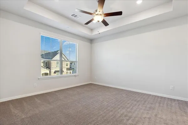 an empty room with windows and ceiling fan