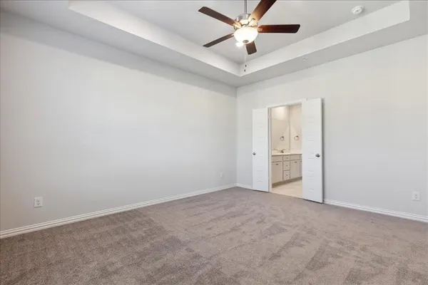 an empty room with a fan & a window