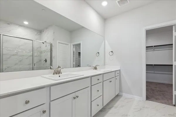 a bathroom with a double vanity sink mirror and shower