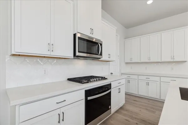 a kitchen with stainless steel appliances granite countertop white cabinets a sink and dishwasher