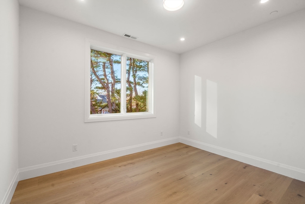 956 Walnut Street, Unit 7 Newton, MA 02461 - Photo 22 of 33 an empty room with wooden floor and window