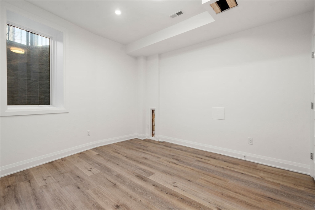956 Walnut Street, Unit 7 Newton, MA 02461 - Photo 25 of 33 an empty room with wooden floor and windows