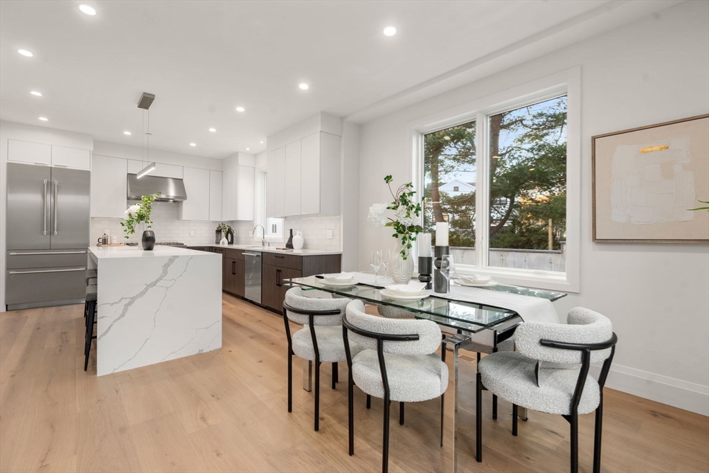 956 Walnut Street, Unit 7 Newton, MA 02461 - Photo 8 of 33 a kitchen view with stainless steel appliances kitchen island granite countertop a dining table chairs and granite counter tops